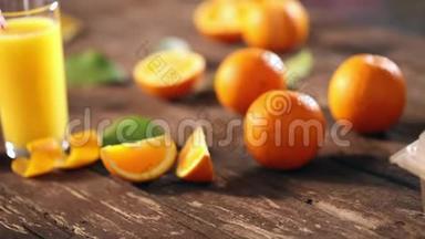 在木制背景下用玻璃切割橘子和果汁。